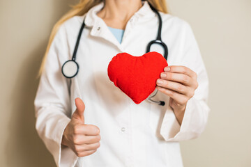 Image of female doctor showing heart  and thumb up.	