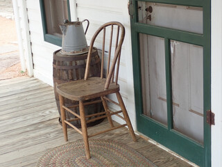 Fototapeta na wymiar Chair and old wooden barrel on the porch by the door