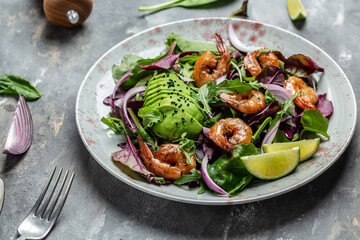 Healthy vegetarian salad with avocado and shrimps salad. Seafood concept. Tasty veg mixed leaves, grilled prawn shrimps, top view