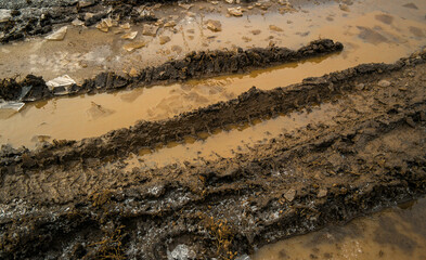 Country dirt road. Background texture of dark brown road dirt with tire tracks