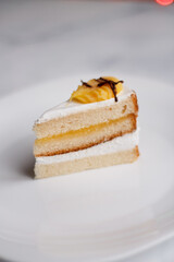 cake on a dessert plate. brownie with white cream on a dark background. cake close-up. cut cake.