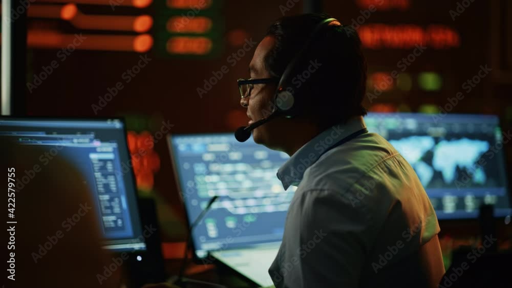 Aufkleber Professional IT Technical Support Specialist and Software Developer Working on Computer in Monitoring Control Room with Digital Screens. Employee Puts on Headphones with Mic and Talking on a Call.