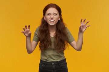 Portrait of angry, savage lady with long ginger hair. Wearing green t-shirt. Emotion concept....