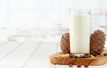 Cedar milk with pine nuts over white wooden table