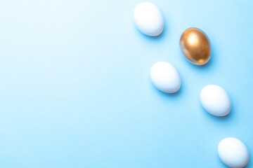 Easter pattern. Golden, white colour egg on pastel blue background in Happy Easter decoration. Spring holiday top view concept.