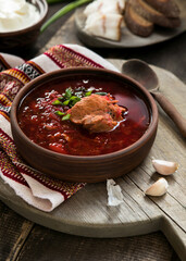 Borscht with sour cream on the wooden table close-up - a dish of traditional Russian and Ukrainian cuisine