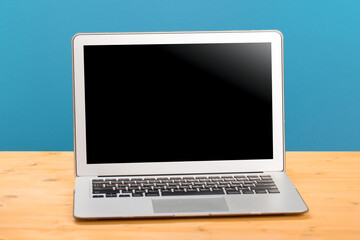 Laptop with blank screen for product display in office with modern blurred background