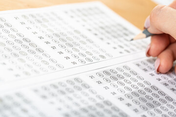 student hand test in exercise and passing examination paper computer worksheet with pencil in school test room, education concept