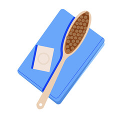 dry massage brush made of natural bristles on a blue towel next to a bar of soap.
