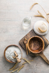 Fototapeta na wymiar Wheat rye spikelets and flour in wooden bowl and spoon