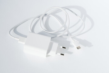 Cable plug usb charger on white background, top view. Minimalistic technology concept