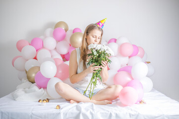 Obraz na płótnie Canvas Young beautiful girl woke up surrounded by balloons on Birthday Day