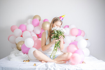 Young beautiful girl woke up surrounded by balloons on Birthday Day