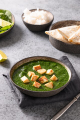 Indian dish Palak Paneer of spinach and paneer cheese on grey background. Vertical orientation. Close up.