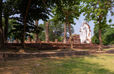Obraz premium The old white Buddha statue is standing in the church ruins.