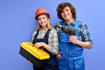 cheerful constructors with instruments tools posing isolated on blue background