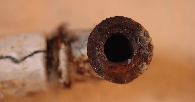 Water leaking from corroded pipe closeup footage