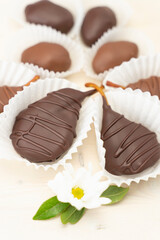 Dried fruit in chocolate: dried pear, peach in chocolate glaze on white background