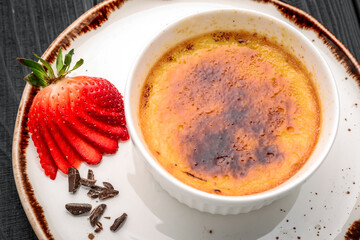 Creme brulee dessert with fresh strawberries and mint leaves