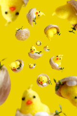 Many chicks explosion and free falling on vibrant yellow background. Creative Easter or animal concept. Selective focus, shallow depth of field.