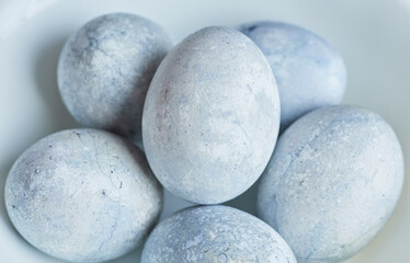 Eggs painted in blue and white are on a plate.
