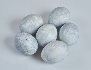 Painted eggs in blue and white lie on a white background.