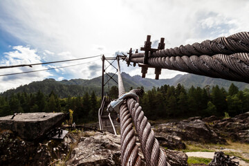 Close-up on a metal binding cable going in perspective to the bridge support with the texture of a...