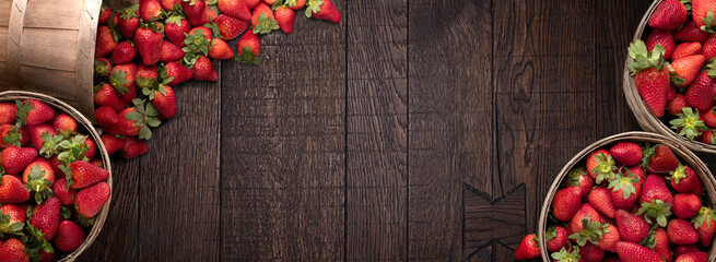 Rustic buckets full of strawberries on wooden floor