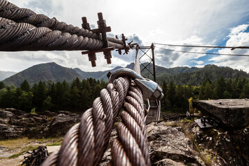 Close-up on a metal binding cable going in perspective to the bridge support with the texture of a...