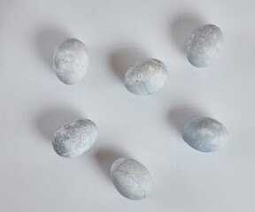 Painted eggs in blue and white lie on a white background.
