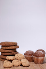muffins, almond amaretti and oat cookies on wooden stand board. sweet bakery concept