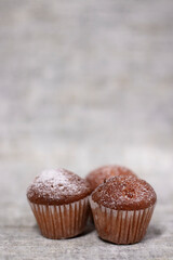 three muffins cupcakes covered in powdered sugar. bakery sweet