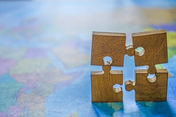 four 4 wooden puzzle on world map background. empty copy space for inscription or other objects....