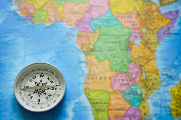 Modern Compass lie on blue world map background. empty copy space for inscription.