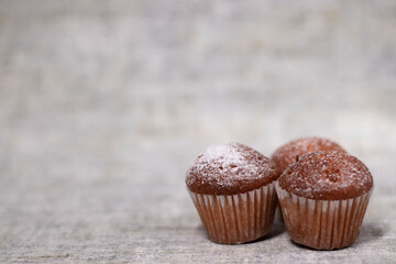 three muffins cupcakes covered in powdered sugar. bakery sweet
