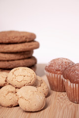 muffins, almond amaretti and oat cookies on wooden stand board. sweet bakery concept