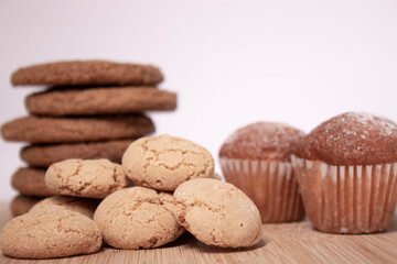 muffins, almond amaretti and oat cookies on wooden stand board. sweet bakery concept