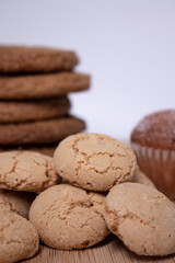 muffins, almond amaretti and oat cookies on wooden stand board. sweet bakery concept