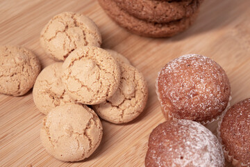 muffins, almond amaretti and oat cookies on wooden stand board. sweet bakery concept