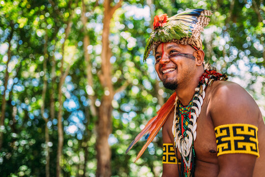 Chief of the Patax&oacute; tribe smiling. Brazilian Indian with feather headdress and necklace looking to the left