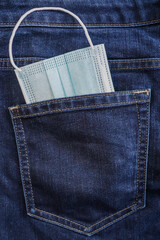 Masks in the pocket of jeans. Coronavirus control.