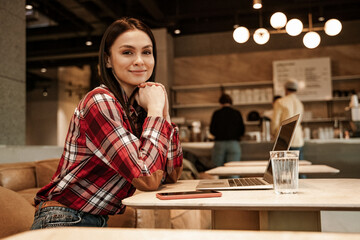 happy freelancer sitting on couch in cafe