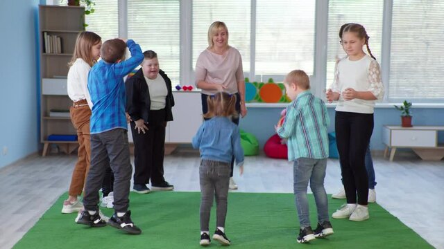 developmental activities in an inclusive classroom with children with down syndrome and throws ball in circle during lesson
