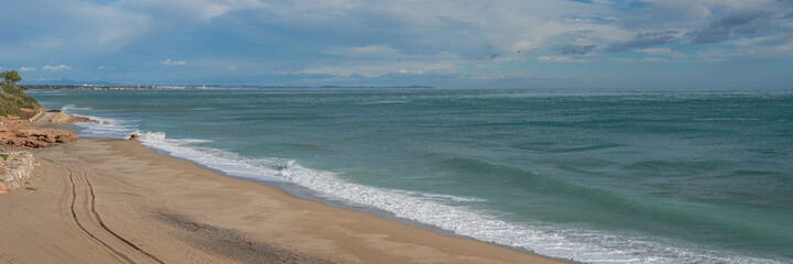 Beautiful beach at Costa Dorada in Miami Platja with a background of blue sky with clouds, Catalonia