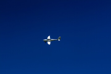 The plane flies in the blue sky