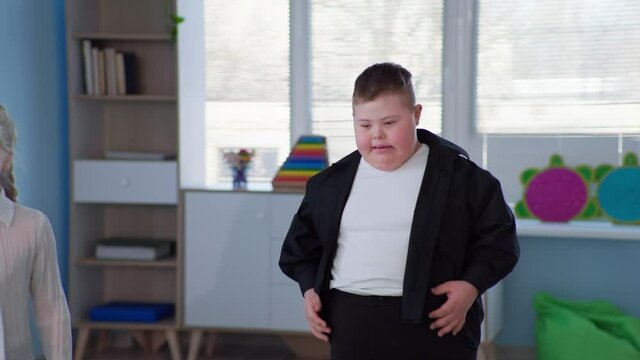 male child with down syndrome playing ball during developmental activities in an inclusive classroom