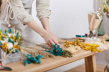 Master florist makes a bouquet of dried flowers at the master class, workshop