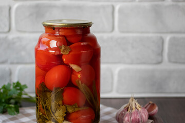 Pickled tomatoes in a glass jar. Homemade.