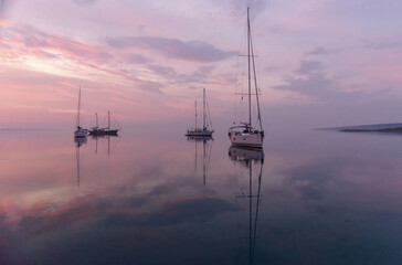 Moored sailboats in the bay before sunrise