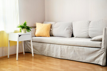 Modern gray sofa with yellow pillow in living room. Living room interior and home decor concep